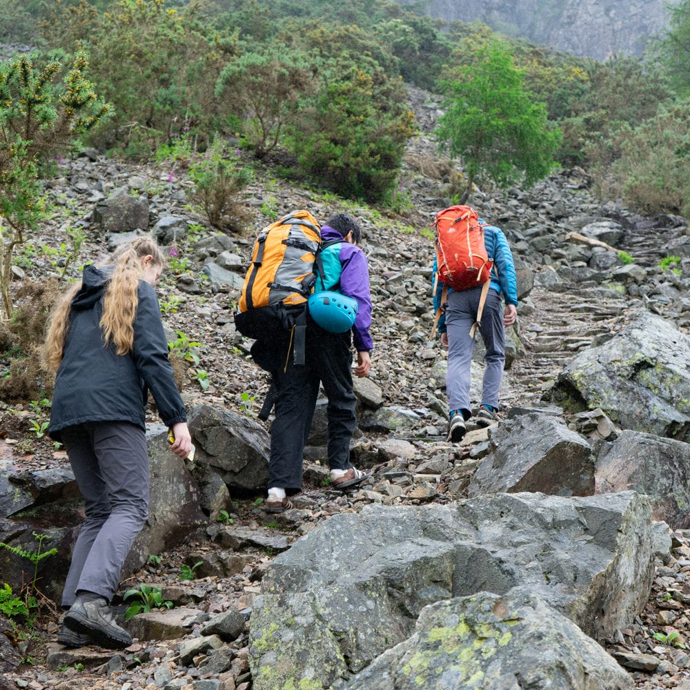 an instructor and two clients on their way to the crag to go rock climbing