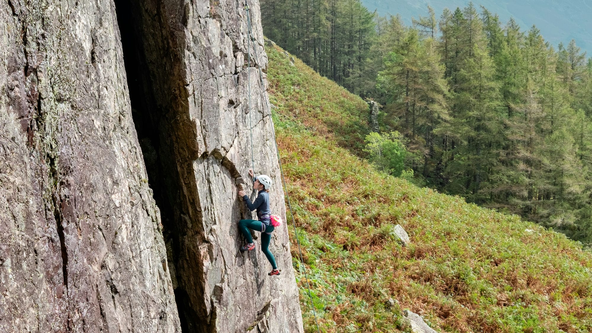 side shot of someone climbing outside on rock